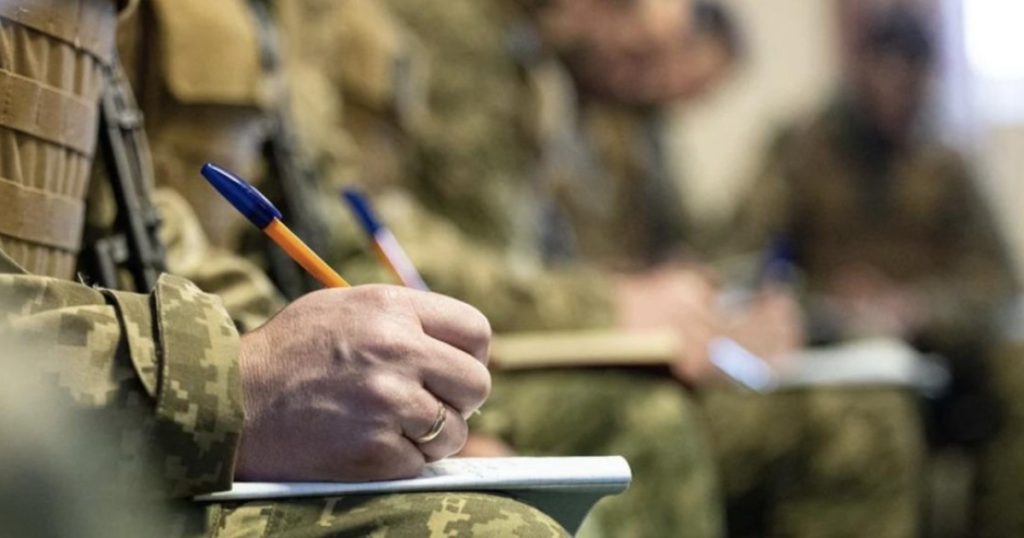 На фото - військові заповнюють документи від руки
