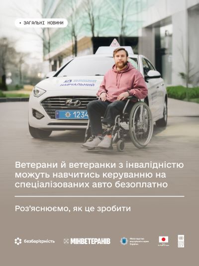 На фото - людина в кріслі колісному поряд з навчальним автомобілем